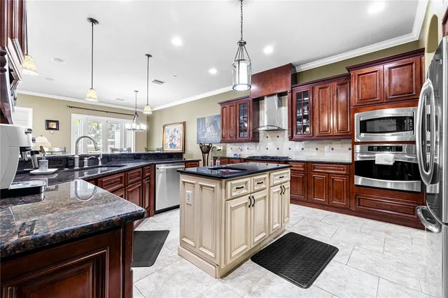 a kitchen with stainless steel appliances granite countertop a stove a sink and a refrigerator