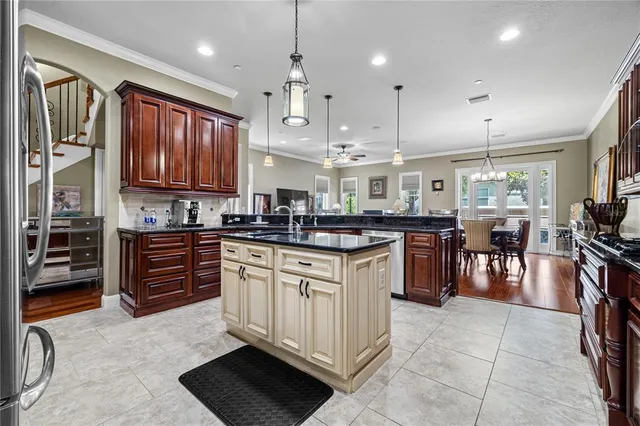 a kitchen with stainless steel appliances granite countertop a stove top oven a sink dishwasher and a refrigerator