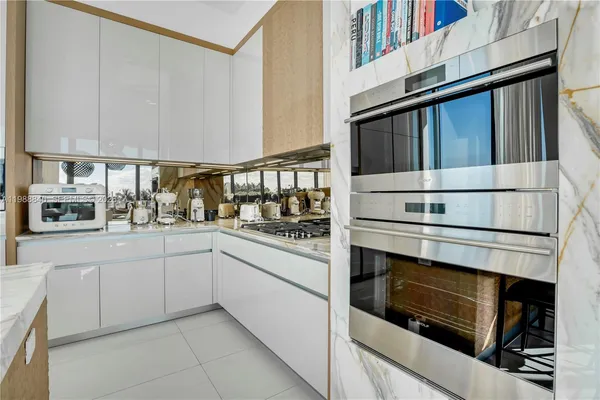 a kitchen with white cabinets and appliances
