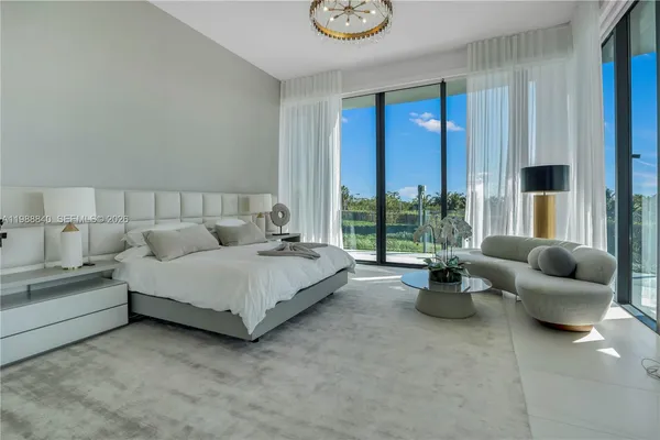 a spacious bedroom with a bed and glass window