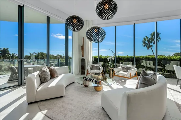 a living room with furniture and a floor to ceiling window
