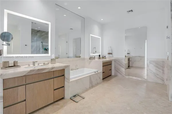 a spacious bathroom with a granite countertop sink mirror and bathtub