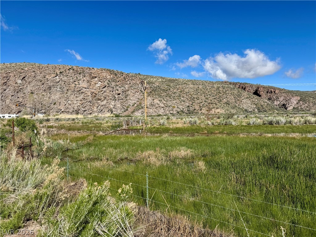 9393 North 93rd Highway Caliente, NV 89008 - Photo 36 of 41 Vast open lands with an irrigation pond, framed by a natural rock wall, provide a tranquil escape.