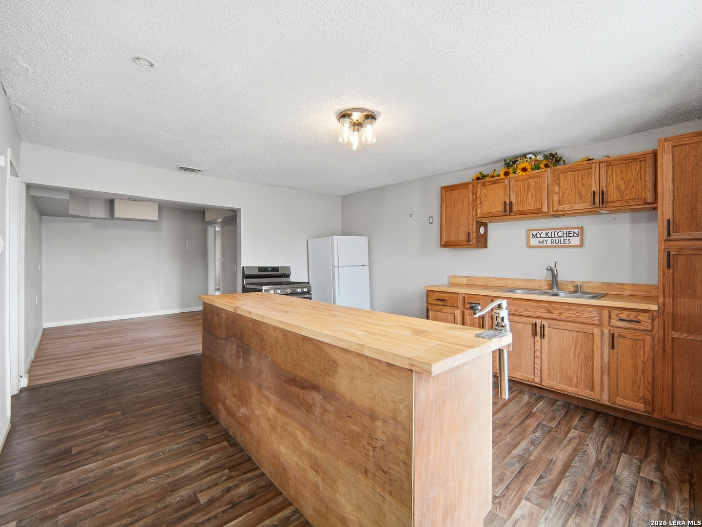 305 Toepperwein Road Converse, TX 78109 - Photo 4 of 25 a large white kitchen with a stove a sink and dishwasher with wooden floor