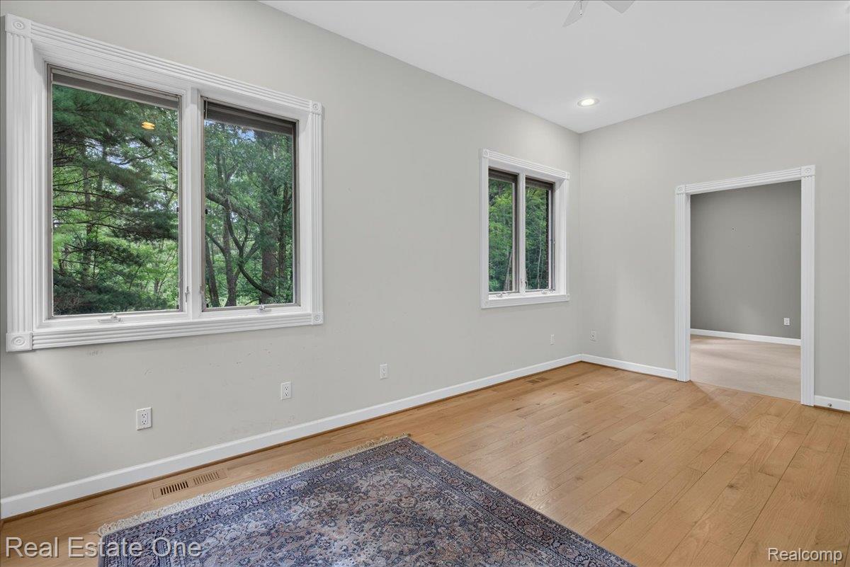425 Courtney Road Leonard, MI 48367 - Photo 51 of 89 Spacious room featuring light wood-finish flooring and two large windows with ornate white trim