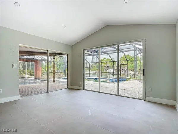 a view of an empty room with wooden floor and a balcony