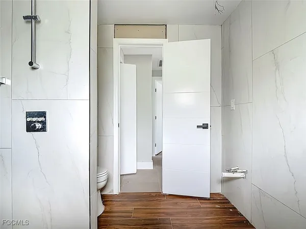 a view of a hallway with wooden floor and closet