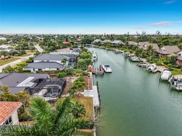 an aerial view of residential houses with outdoor space and lake view
