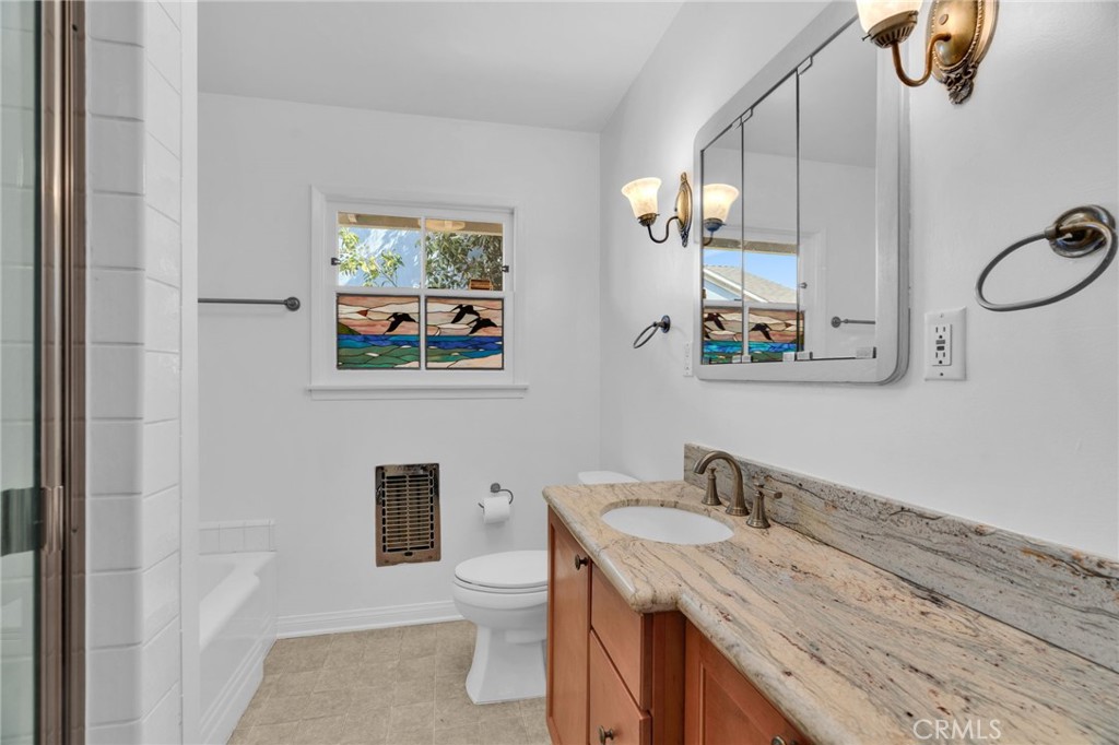 4114 Artesia Boulevard Torrance, CA 90504 - Photo 15 of 21 a bathroom with a granite countertop sink a mirror and a toilet