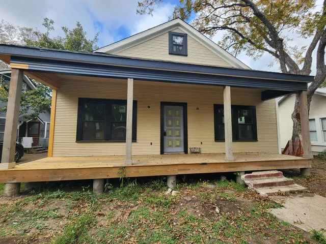 a view of a house with a small yard and wooden floor and a fence
