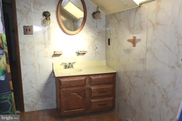 a white toilet sitting next to a white sink and vanity