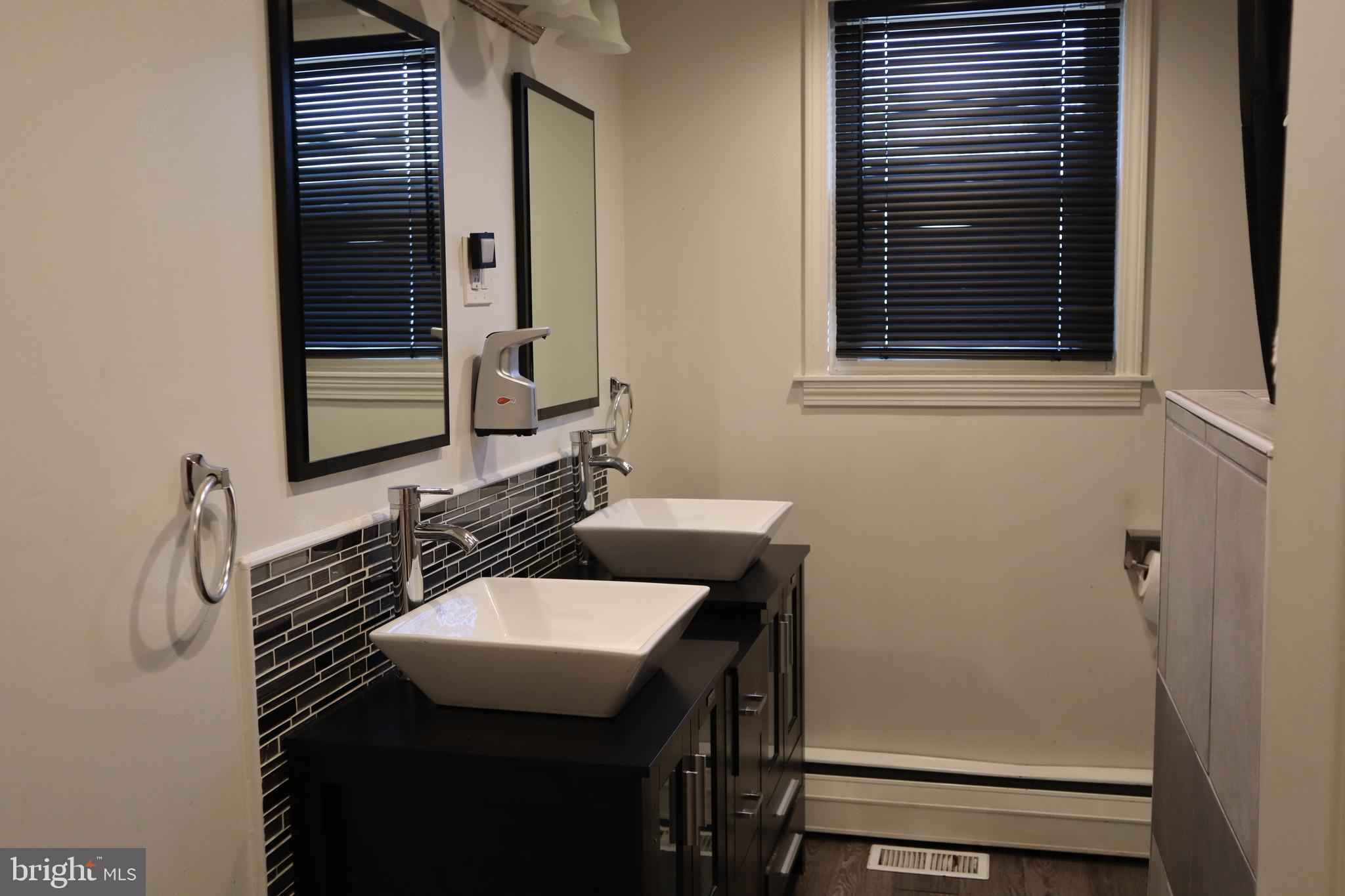 121 Patterson Avenue Bellmawr, NJ 08031 - Photo 9 of 20 a bathroom with a sink a mirror and a window