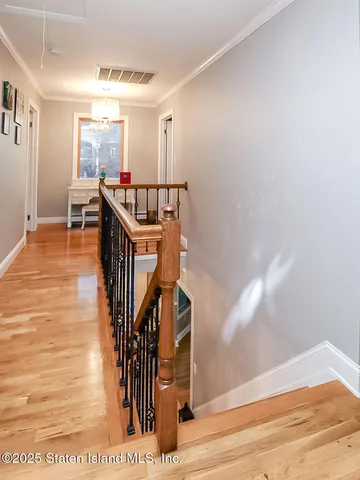 a way to livingroom with wooden floor and staircase