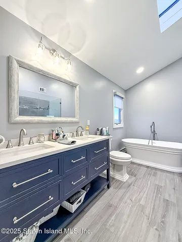 a bathroom with a granite countertop double vanity sink a mirror and a