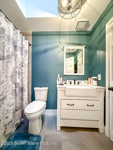 a bathroom with a sink a toilet and a mirror