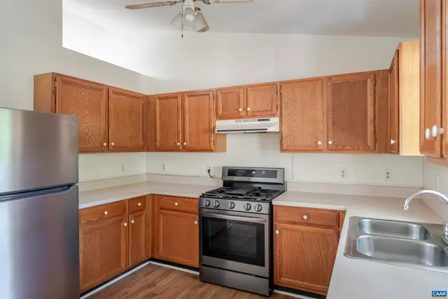 a kitchen with granite countertop a sink stainless steel appliances and cabinets