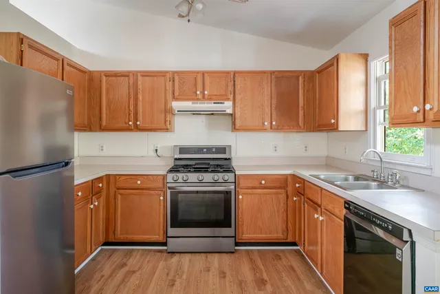 a kitchen with stainless steel appliances granite countertop a stove a sink dishwasher and a refrigerator