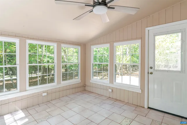 a view of an empty room with a window and a ceiling fan