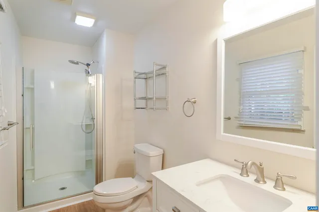 a bathroom with a sink toilet vanity and shower