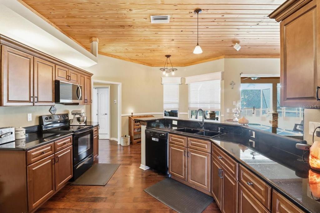 3030 South Bay Berry Point Inverness, FL 34450 - Photo 14 of 48 a kitchen with stainless steel appliances granite countertop a stove a sink dishwasher and a microwave oven with cabinets