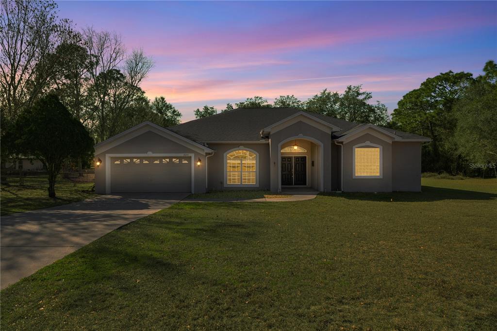 3030 South Bay Berry Point Inverness, FL 34450 - Photo 3 of 48 a front view of a house with a yard and garage