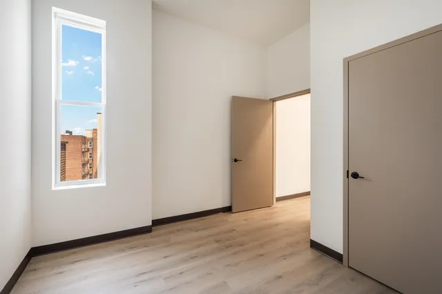 an empty room with windows and closet