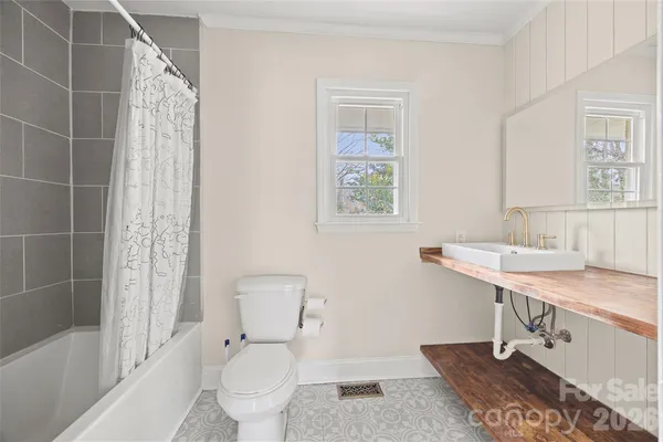 a bathroom with a sink a toilet a mirror and shower
