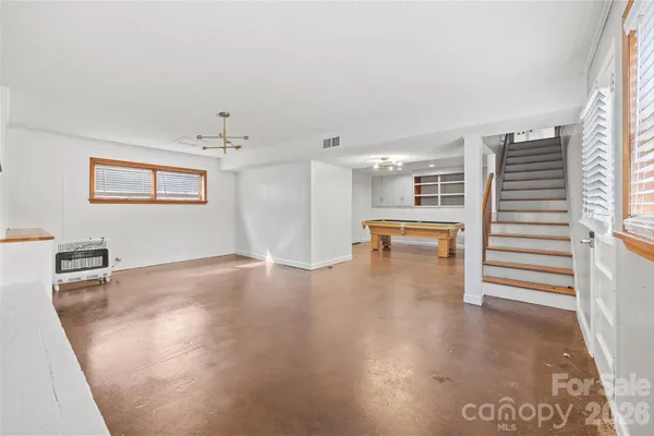 a living room with stainless steel appliances kitchen island a table and chairs in it