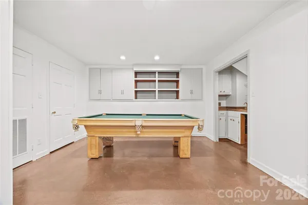 a view of an empty room with a window and kitchen view