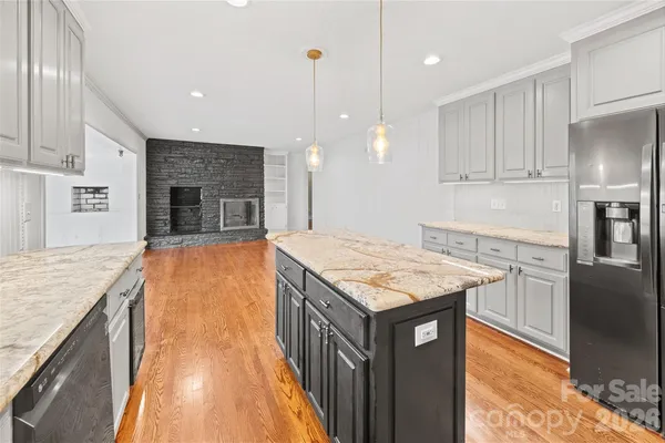 a kitchen with kitchen island a counter top space a sink stainless steel appliances and cabinets