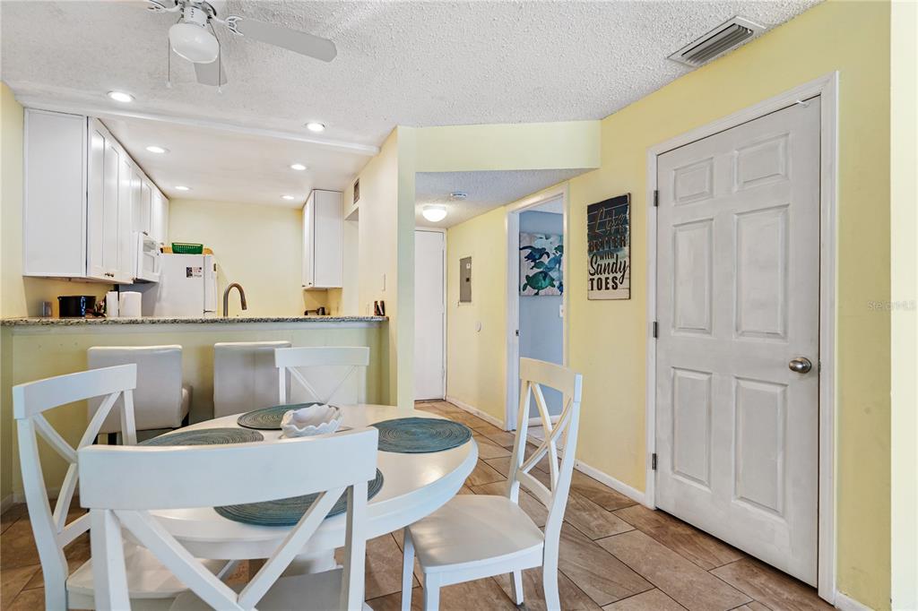 230 Medallion Boulevard, Unit E Madeira Beach, FL 33708 - Photo 8 of 35 a dining area with a table chairs and a kitchen