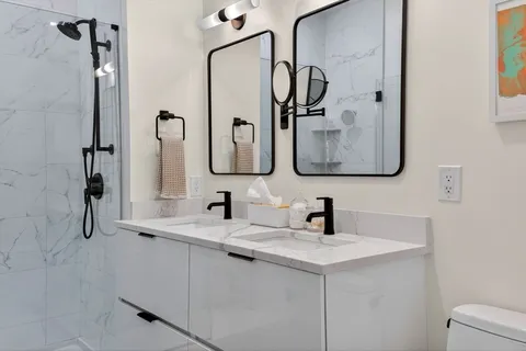 a bathroom with a double vanity sink mirror and