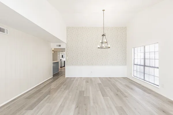 a view of empty room with wooden floor and window