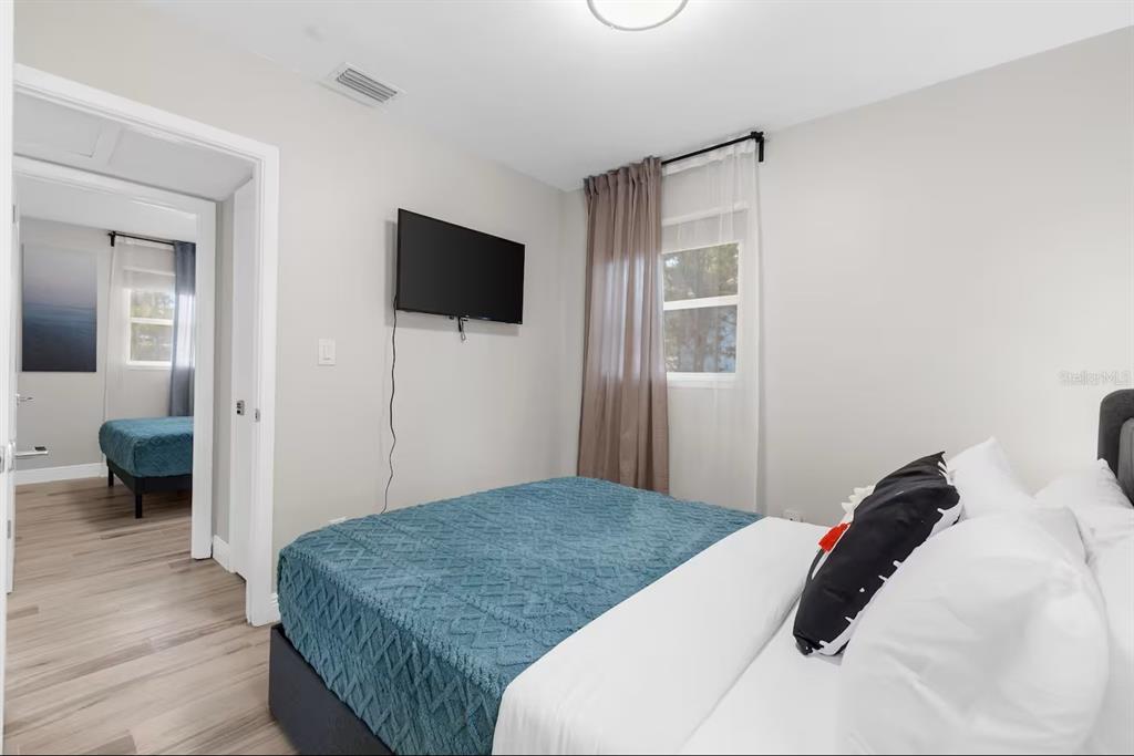 8215 Quail Road Seminole, FL 33777 - Photo 12 of 25 a bedroom with a bed and a flat screen tv