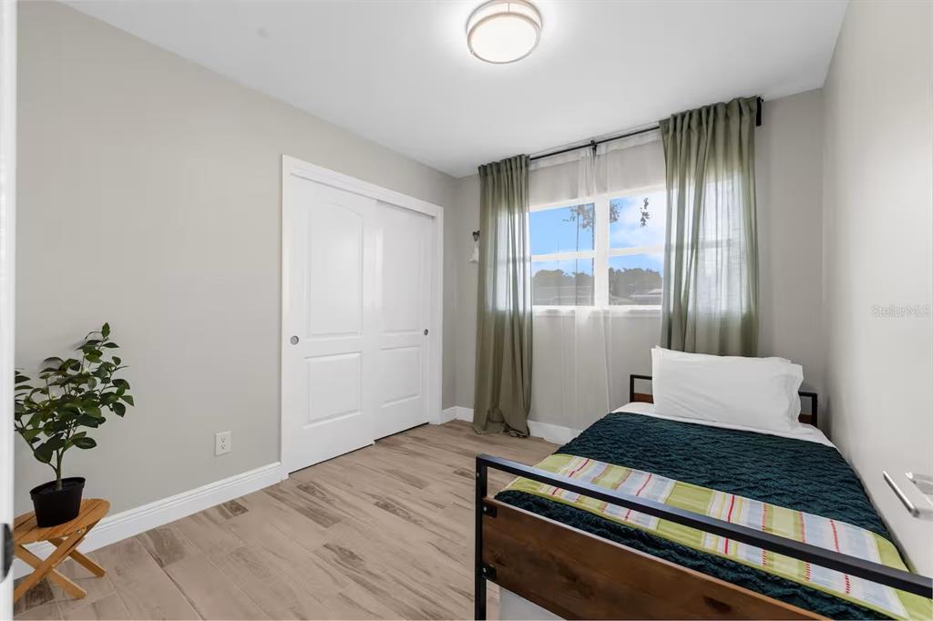 8215 Quail Road Seminole, FL 33777 - Photo 14 of 25 a bedroom with wooden floor and a window