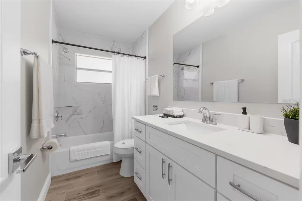 8215 Quail Road Seminole, FL 33777 - Photo 15 of 25 a bathroom with a double vanity sink toilet mirror and bathtub