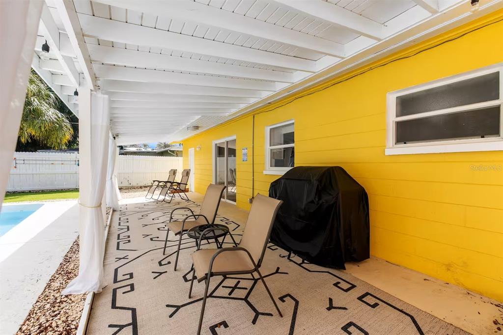 8215 Quail Road Seminole, FL 33777 - Photo 17 of 25 view of living room with furniture and floor to ceiling window