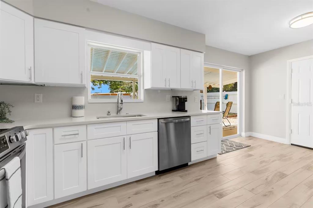 8215 Quail Road Seminole, FL 33777 - Photo 6 of 25 a kitchen with white cabinets and sink
