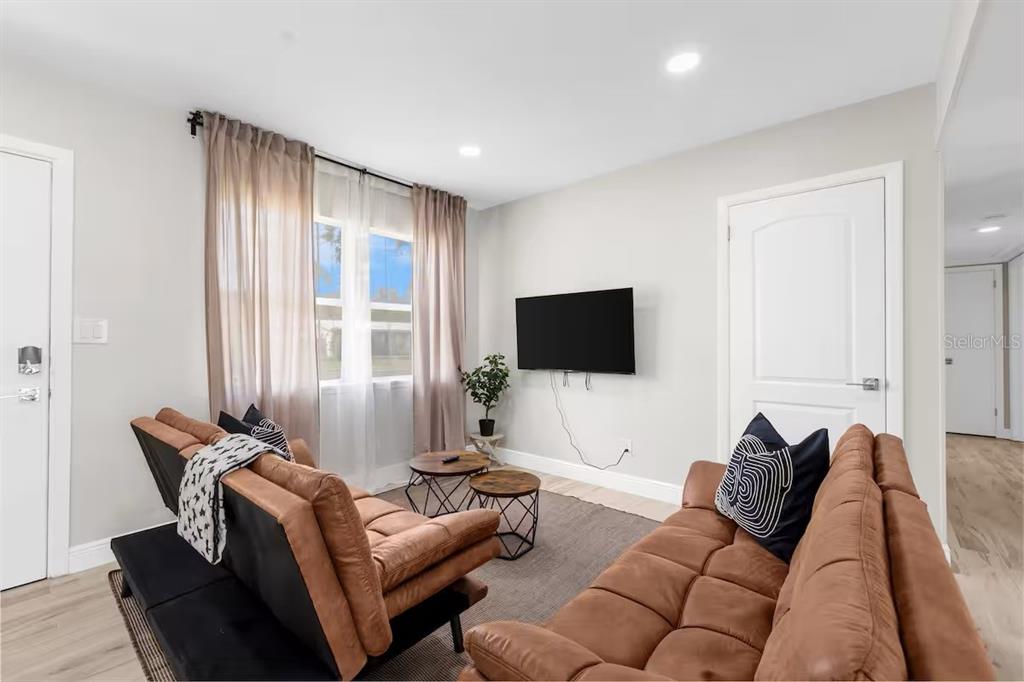 8215 Quail Road Seminole, FL 33777 - Photo 10 of 25 a living room with furniture and a flat screen tv