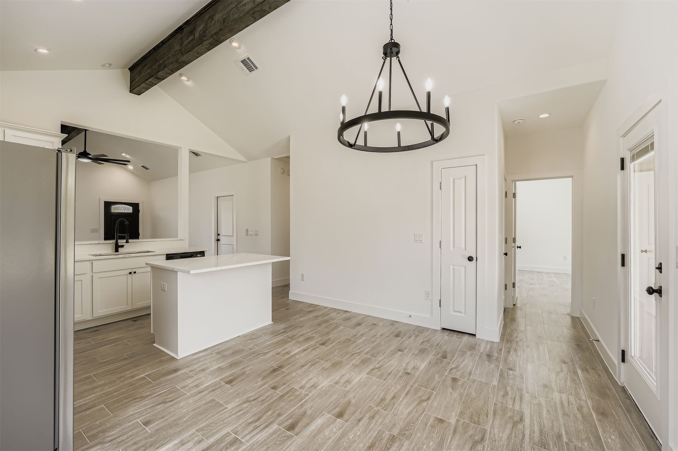 701 East 3rd Street Elgin, TX 78621 - Photo 12 of 35 Kitchen with a center island, beamed ceiling, white cabinetry, and ceiling fan