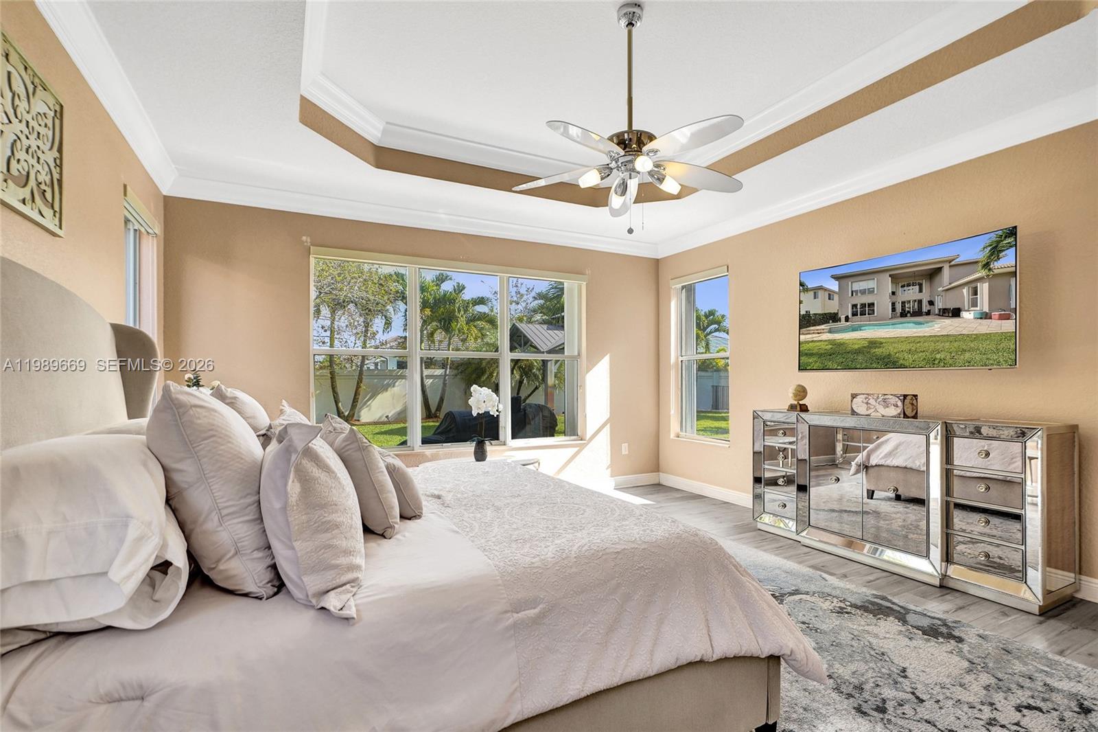 17713 Southwest 47th Street Miramar, FL 33029 - Photo 36 of 94 a spacious bedroom with a bed a chandelier and glass door