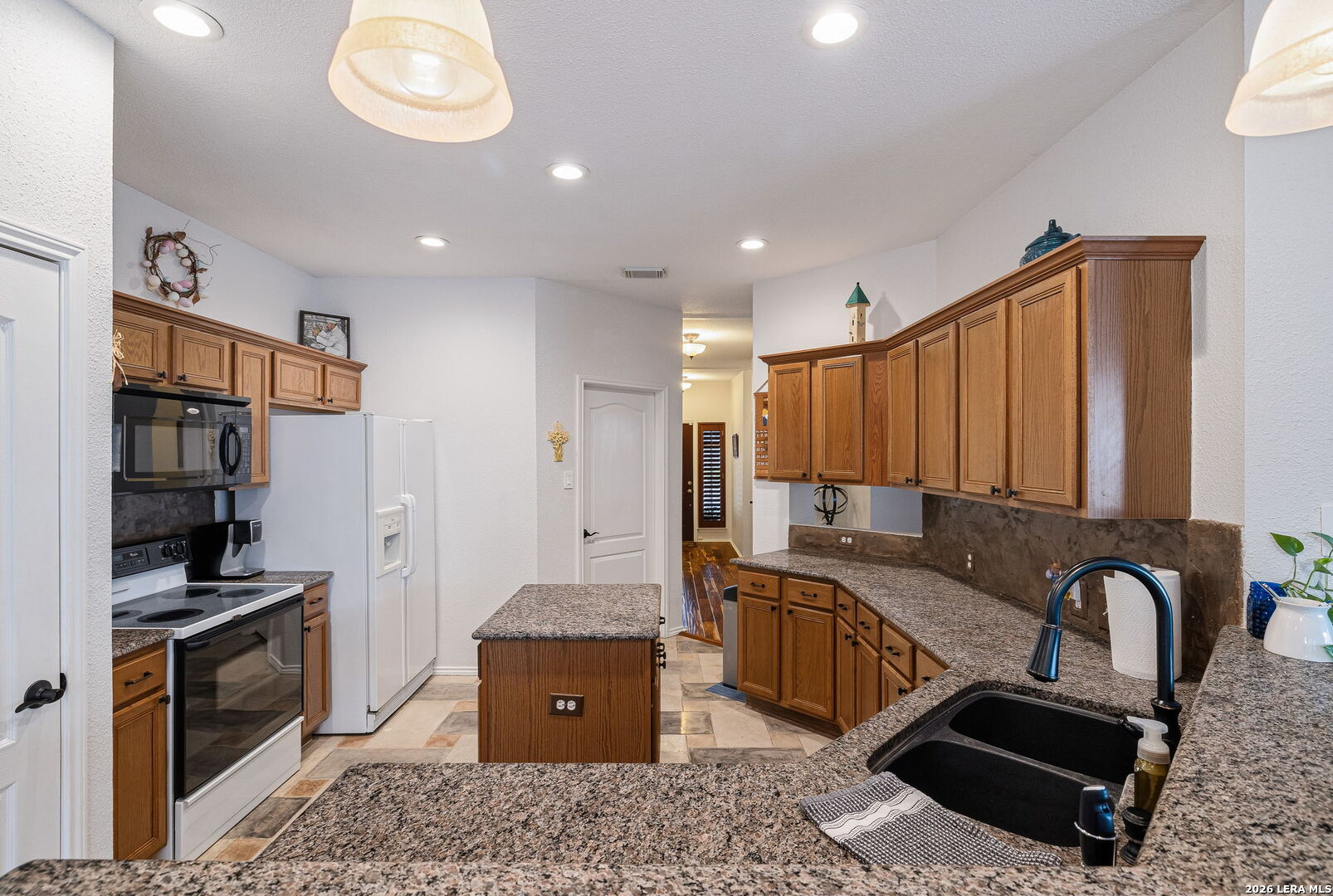 229 Notch Leaf Cibolo, TX 78108 - Photo 14 of 30 a kitchen with stainless steel appliances granite countertop a sink a stove and a refrigerator