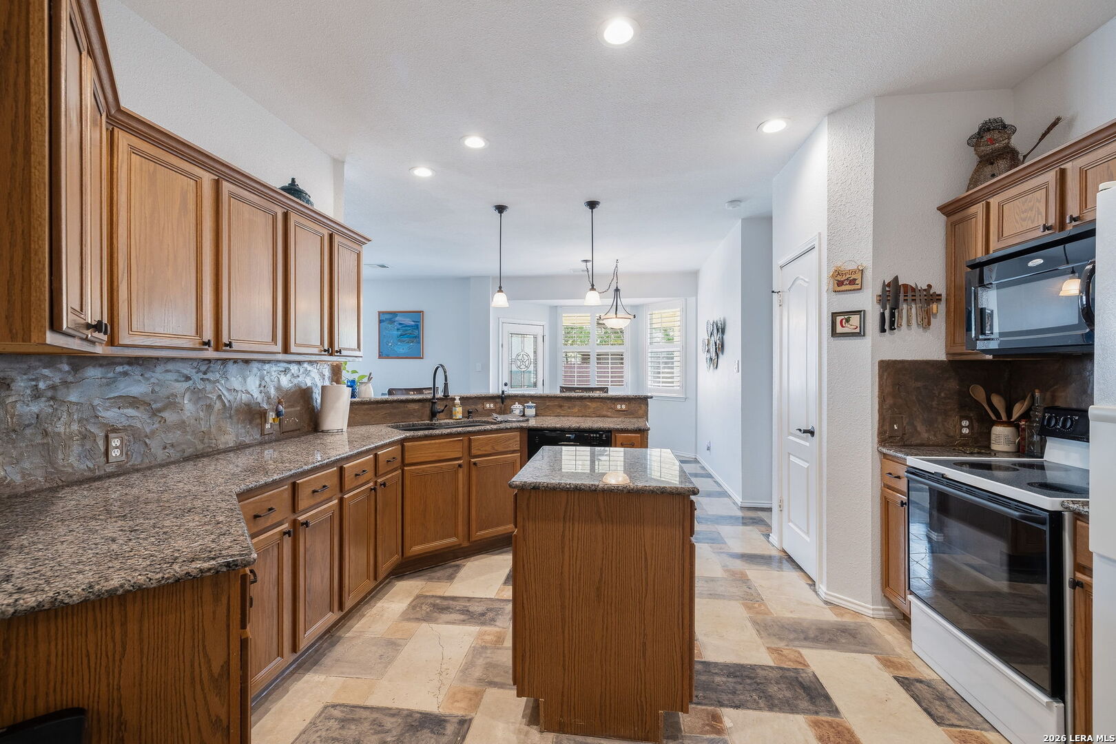 229 Notch Leaf Cibolo, TX 78108 - Photo 16 of 30 a kitchen with stainless steel appliances granite countertop a stove top oven a sink dishwasher and a refrigerator with wooden floor