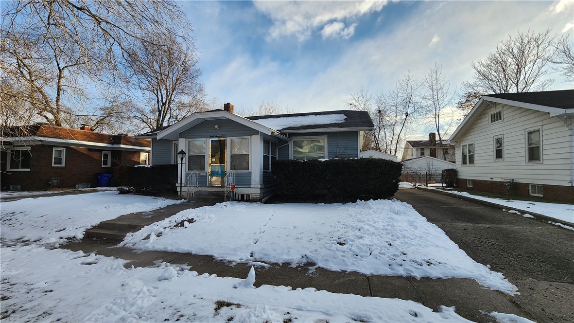 a front view of a house with a yard covered in snow
