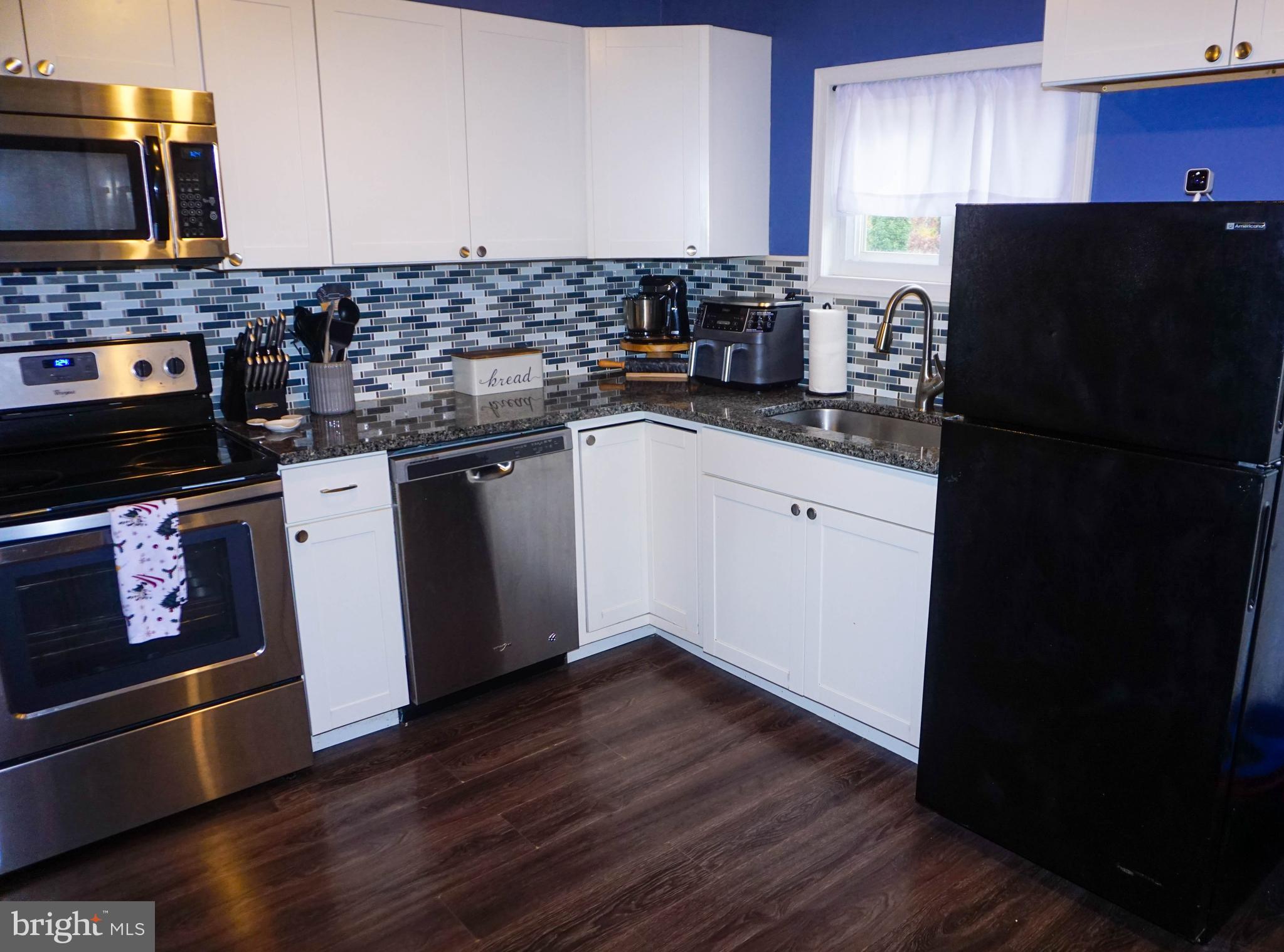 91 Mt Clement Avenue Pine Hill, NJ 08021 - Photo 10 of 27 a kitchen with a refrigerator stove and wooden cabinets