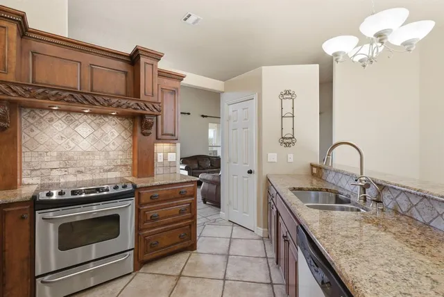 a kitchen with stainless steel appliances granite countertop a stove and a sink