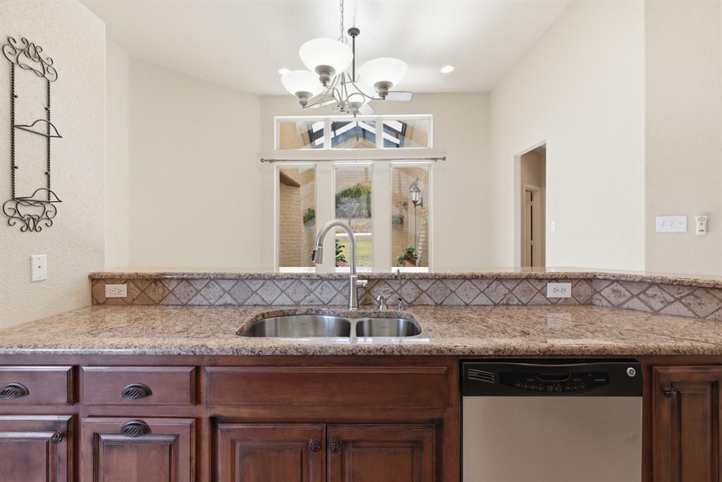 6525 Compass Way Bluff Dale, TX 76433 - Photo 18 of 40 a sink with granite countertop a sink and chandelier