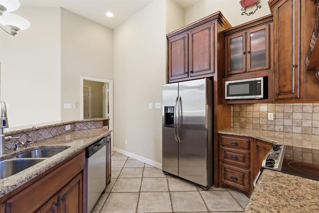 6525 Compass Way Bluff Dale, TX 76433 - Photo 19 of 40 a kitchen with stainless steel appliances granite countertop a refrigerator and a sink