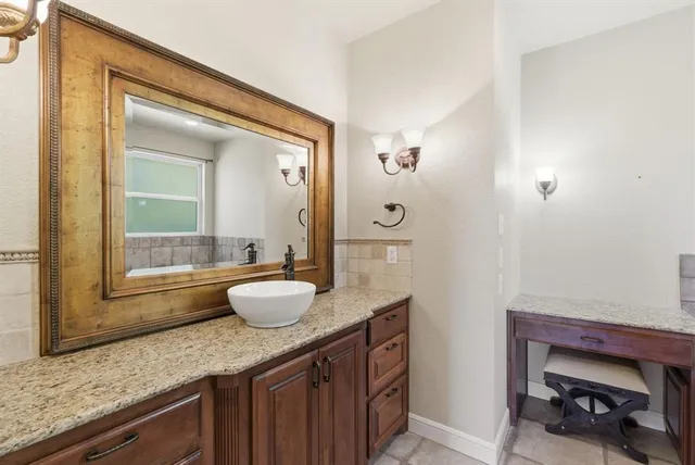 a bathroom with a granite countertop sink and a mirror