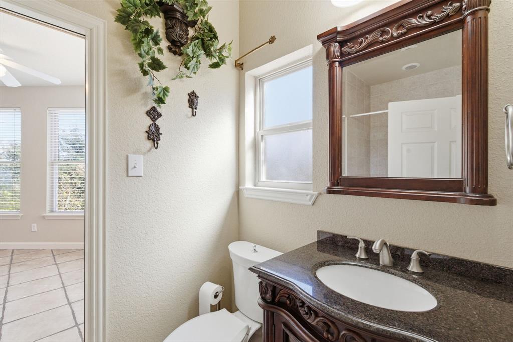 6525 Compass Way Bluff Dale, TX 76433 - Photo 32 of 40 a bathroom with a sink vanity mirror and toilet